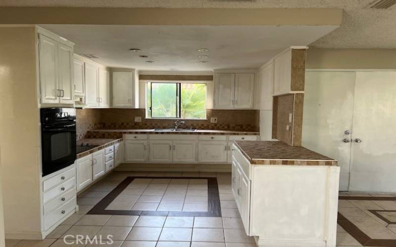 Kitchen has oven and glass top range.