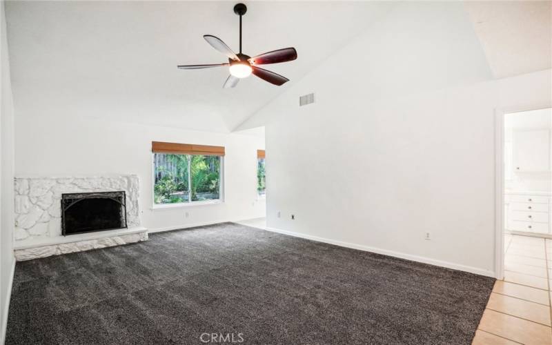 Living room with fireplace and ceiling fan.