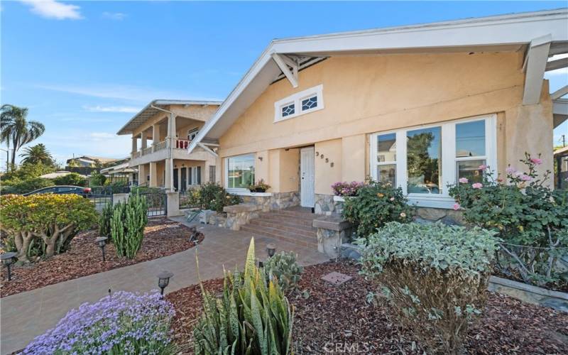 Beautiful native plants envelope a Craftsman style build with natural stone highlights