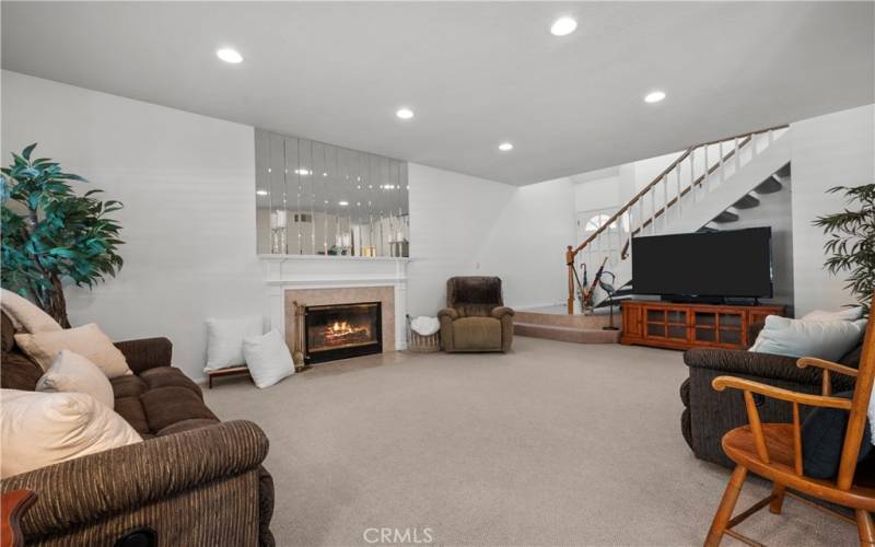 Front door with stair case and family room.