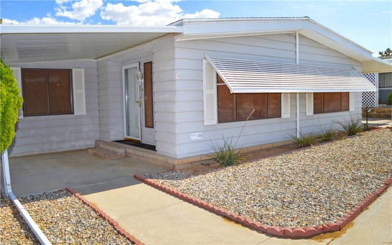 Nice curb appeal with easy-care desert landscaping and a covered front porch. Awnings keep the living room cooler.