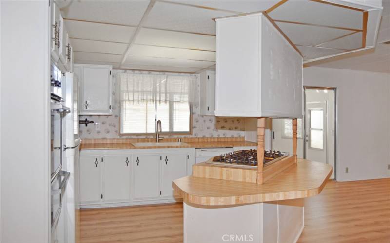 The spacious kitchen has been upgraded with a new gas cooktop (2023), and a sink, faucet, and disposal in 2017. There's seating at the island and plenty of counter and cabinet space for multiple cooks in this kitchen. White cabinetry gives it a fresh, modern feeling.