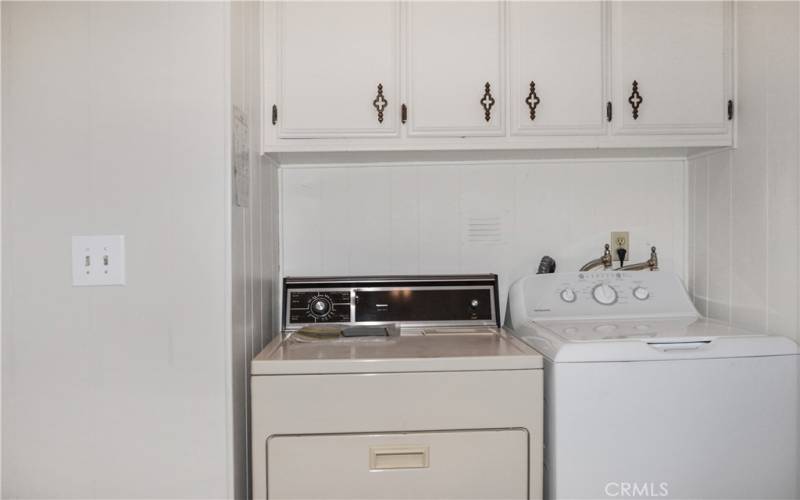 Laundry room with washer and dryer included, lots of storage in the cabinets and closet, and carport access