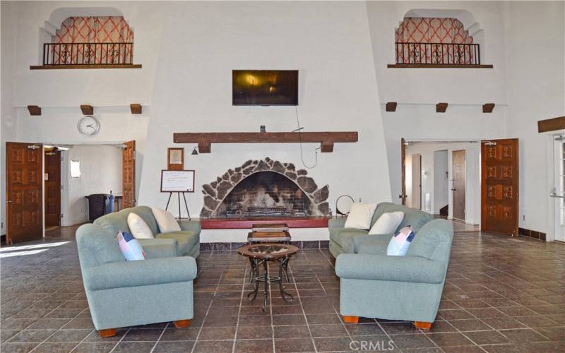 Comfortable seating by this massive fireplace with a TV for residents to use.