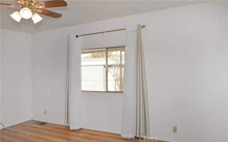 The nice-sized primary bedroom suite offers views of the backyard, en suite bath, walk-in closet, and a ceiling fan.