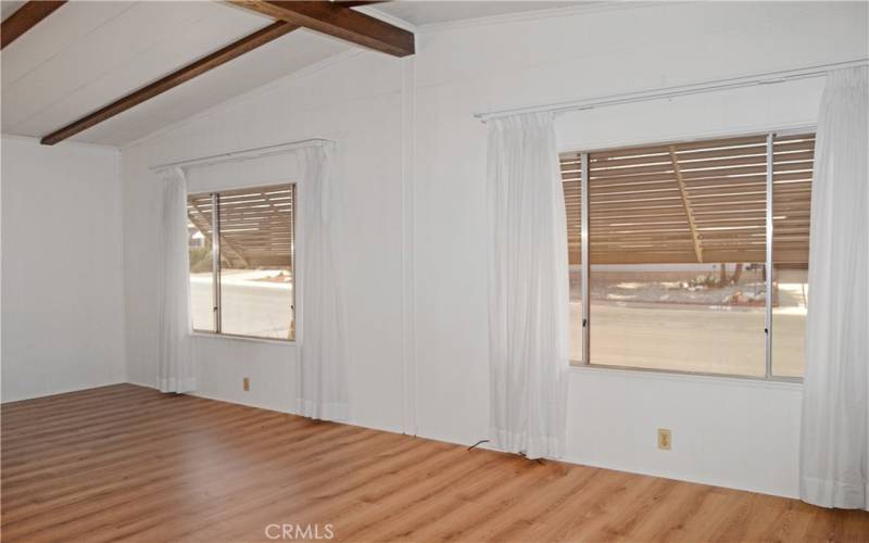 Large windows at the front of the spacious living room create a light and bright space while the awnings outside keep the heat at bay.