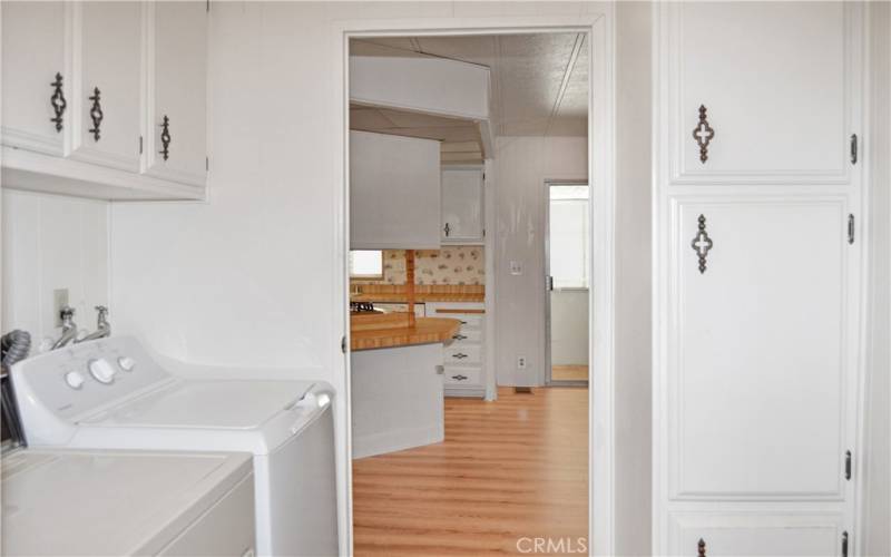 Laundry room with washer and dryer included, lots of storage in the cabinets and closet, and carport access