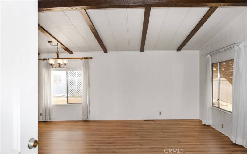 Come on in! Notice the attractive laminate flooring throughout which was just installed in April and the dramatic beamed ceilings.