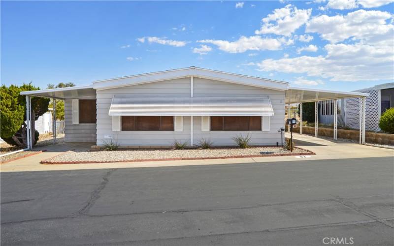 Nice curb appeal with easy-care desert landscaping and a covered front porch. Awnings keep the living room cooler.