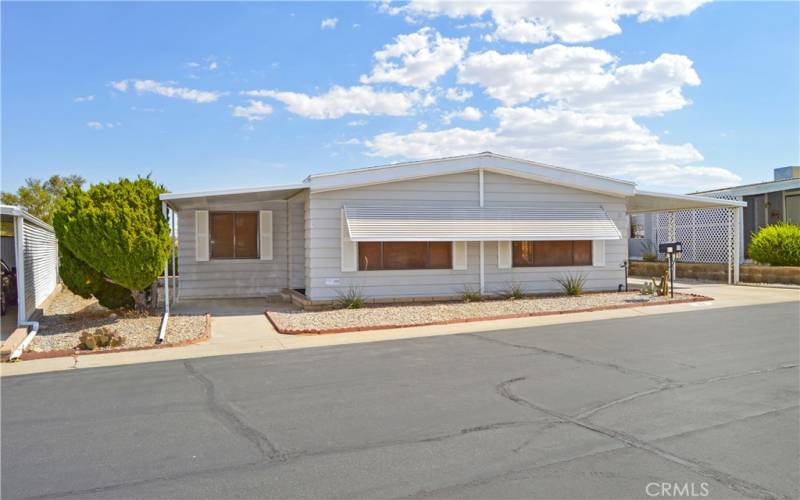 Nice curb appeal with easy-care desert landscaping and a covered front porch. Awnings keep the living room cooler.