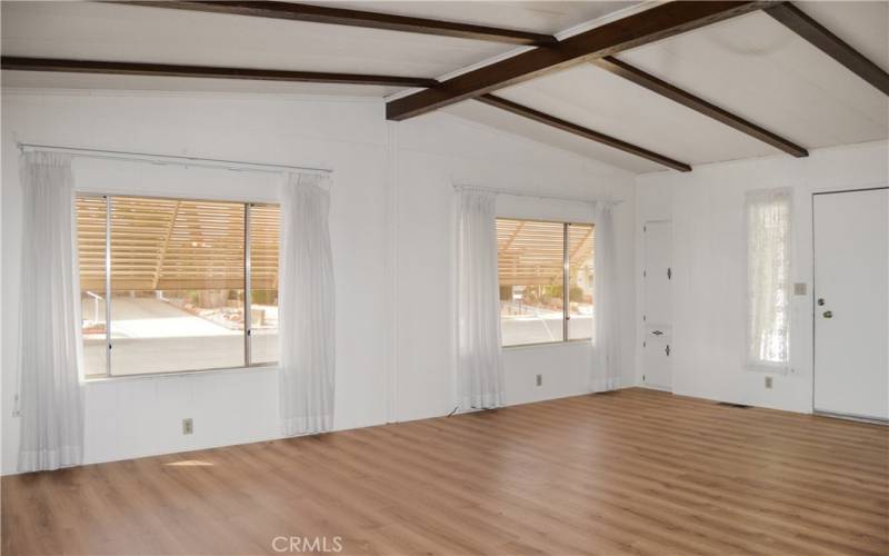 Large windows at the front of the spacious living room create a light and bright space while the awnings outside keep the heat at bay.