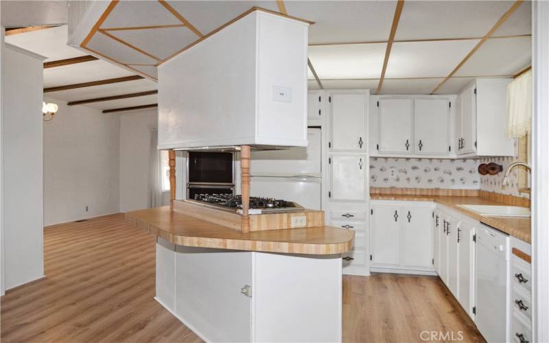 The spacious kitchen has been upgraded with a new gas cooktop (2023), and a sink, faucet, and disposal in 2017. There's seating at the island and plenty of counter and cabinet space for multiple cooks in this kitchen. White cabinetry gives it a fresh, modern feeling.