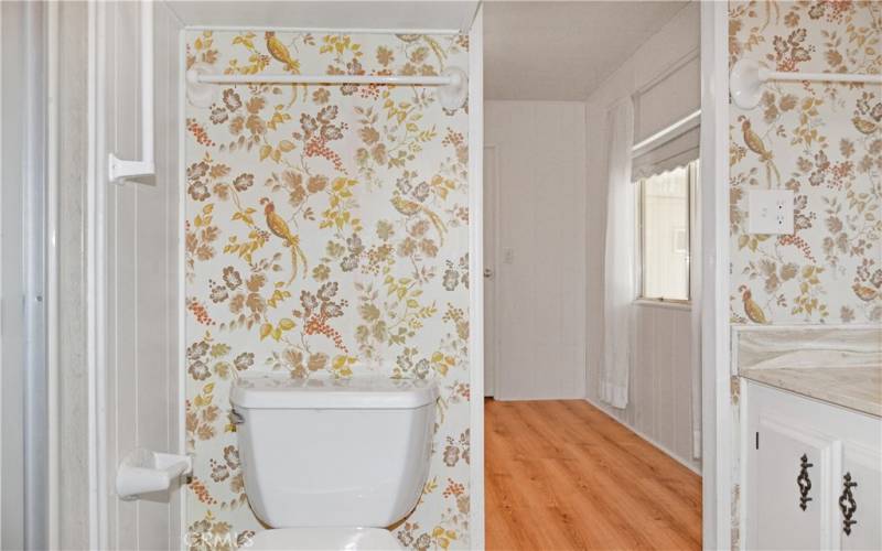 The 2nd bath offers direct access to the 2nd bedroom, a stall shower, and a cheerful bird-themed wall covering