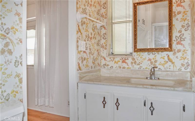 The 2nd bath offers direct access to the 2nd bedroom, a stall shower, and a cheerful bird-themed wall covering