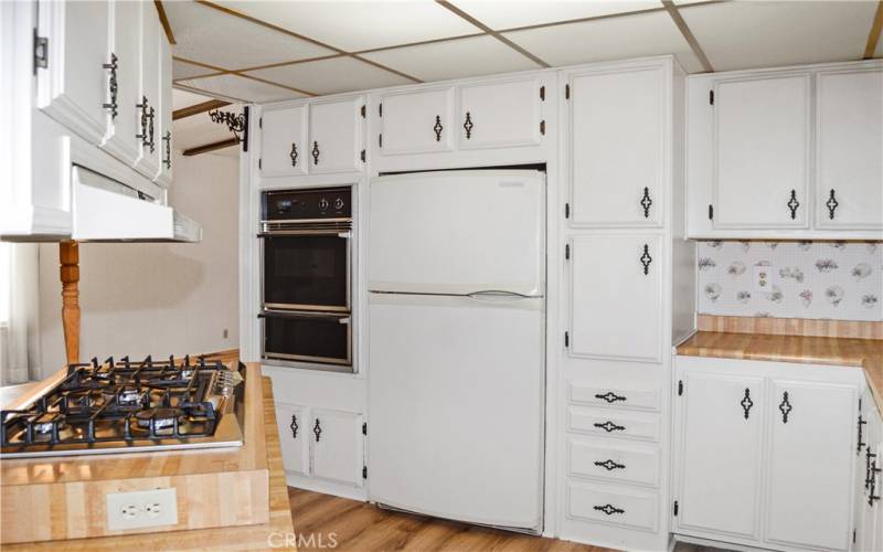 Lots of cabinetry, a wall oven with a broiler below, and the refrigerator are all included.