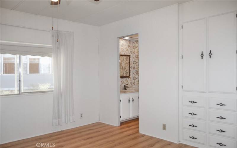 The 2nd bedroom has direct access to the 2nd bath, built-in cabinetry, a walk-in closet, and a ceiling fan which make it feel like another primary suite.