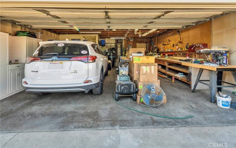 Attached garage with storage cabinets and storage above