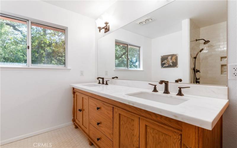 The main bathroom has been tastefully remodeled with a sophisticated dual sink vanity with quartz countertops.