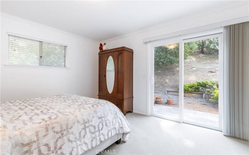 The primary bedroom offers a sliding glass door that leads out to a patio.