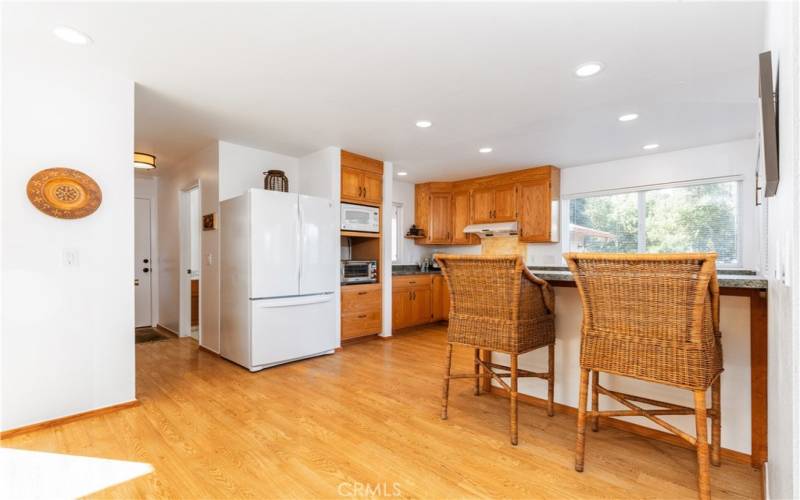 The laminate wood floors extend throughout the large kitchen and dining area.