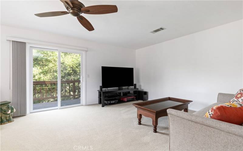 Comfortable living room with lots of natural light and a sliding glass door to the side deck.