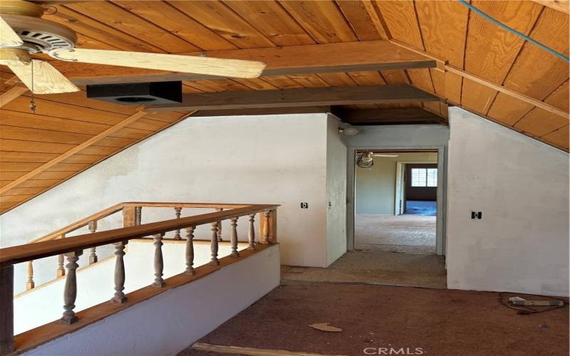 Upstairs loft looking into bedroom and bonus room.  Connection in ceiling for  stove pipe from wood stove that was once in living room below.