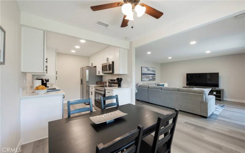 Dinette with seating for four, ceiling fan and adjacent kitchen