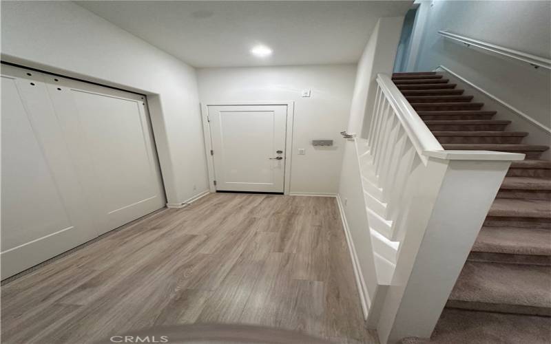 A den/flexible room space with doors  is  on the left when you enter the home.  The door at the end of the hall leads to the garage.