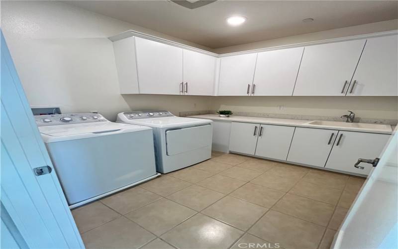 Large laundry room with a sink, counters and cabinets. Washer and dryer included!