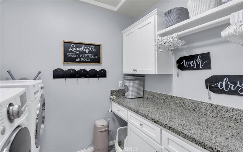 upstairs laundry room with storage and countertop work space