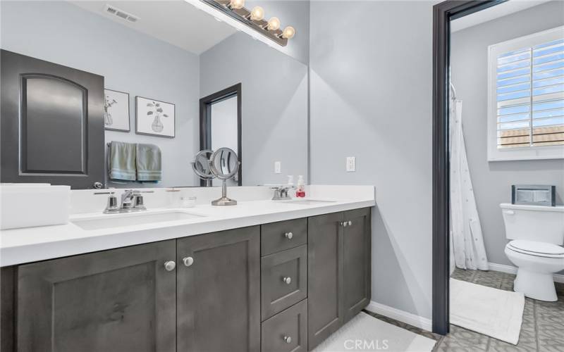 Guest bathroom with double sink and tiled flooring