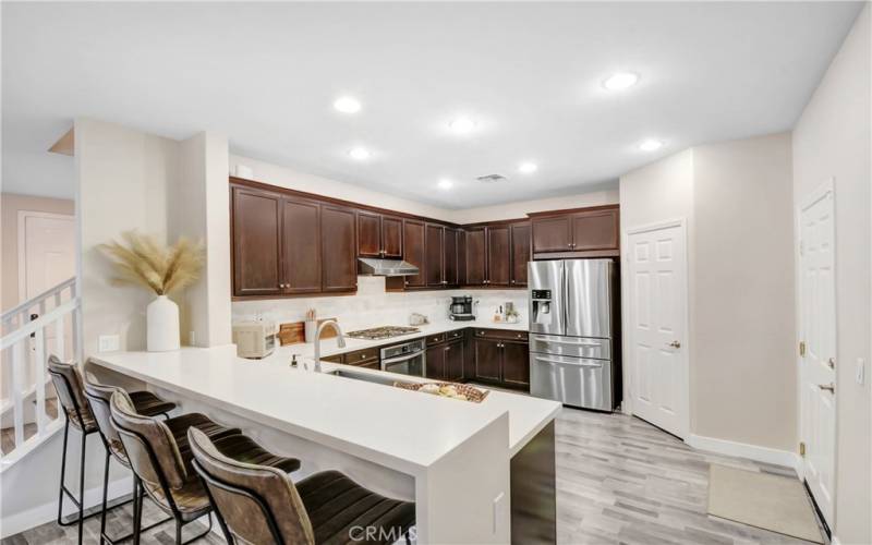 Kitchen with over the counter seating, walk in pantry, and direct access to the garage.