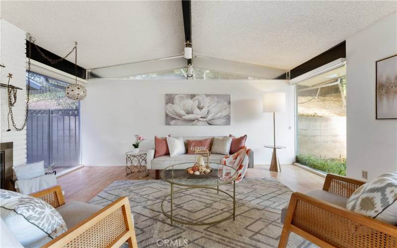 Inviting formal living room with mid century charming light hanging near the window closes to the fireplace.