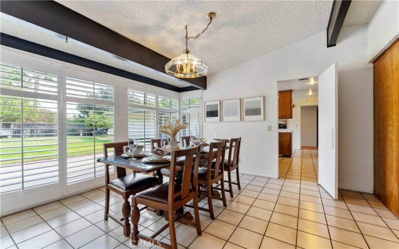 Wall to wall windows offer view of spacious backyard. Throughway to kitchen. Throughway beyond kitchen leads to hallway to bedrooms/bathrooms/laundry.