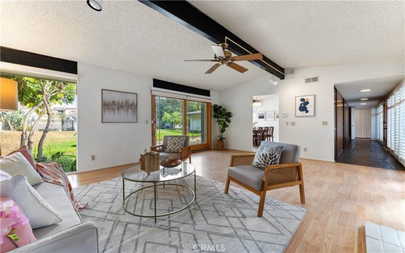 Formal living room with sliders and large window view of the backyard. Right throughway is the entrance to the home. Throughway left side leads to formal dining and kitchen.