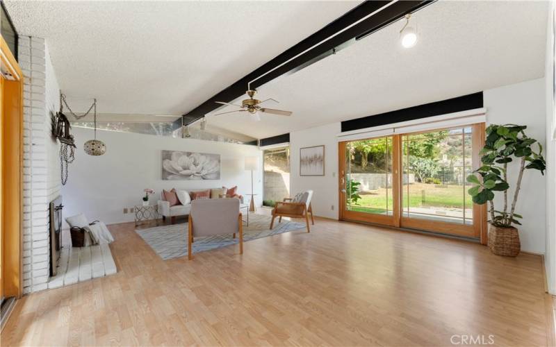 Fabulous Formal living room with fireplace and sliders on both sides allowing natural light to come in.