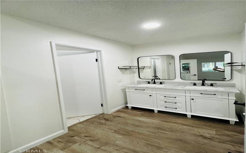 Double sink vanity in between master bedroom and door to enter bathroom