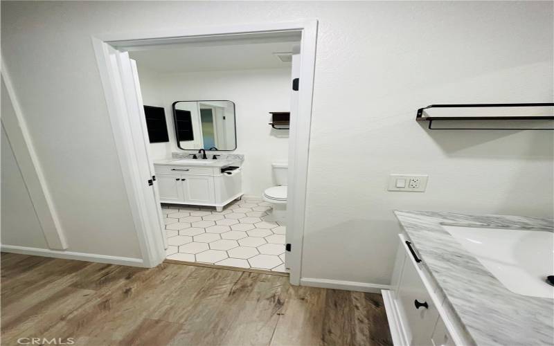 Double sink in between master and bathroom, as well as showing door to access bathroom