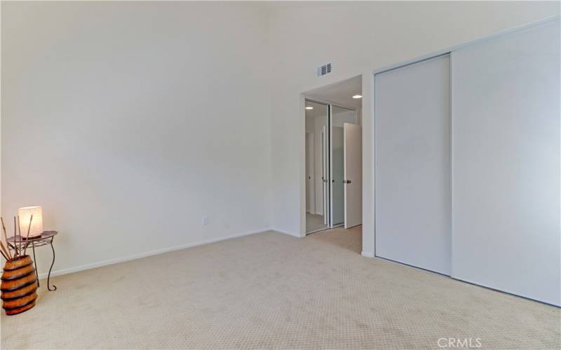 Primary bedroom 2 facing both closets.  Mirrored closet to left leading en suite bathroom.