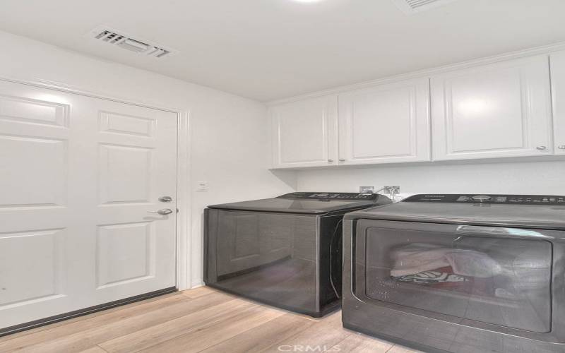 Laundry Room conveniently located near kitchen and garage with storage cabinets!