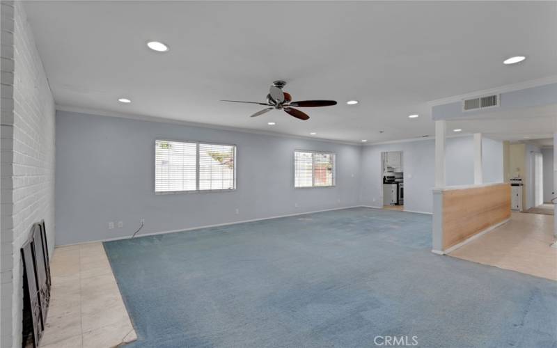 Spacious living room with fireplace, recessed lighting and ceiling fan