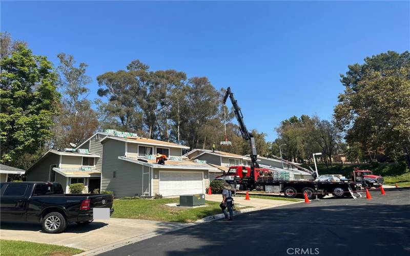 Roofers working on installing new roofing of the homes in the community. New roofing paid for by the HOA.