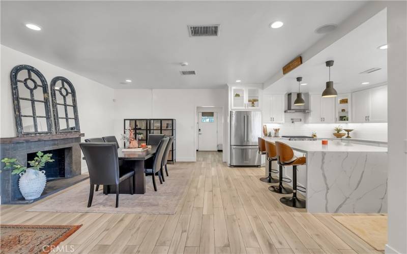 Formal dining room with wood-burning fireplace is wide open to the kitchen.