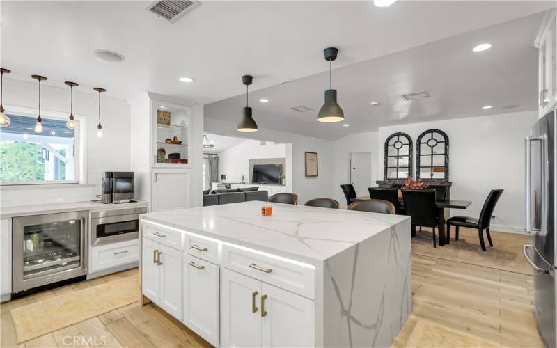 Gorgeous waterfall kitchen island that opens up into the formal dining room with fireplace.