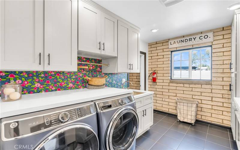 Large indoor laundry room with sink and lots of cabinetry off the kitchen. Washer and dryer not included.