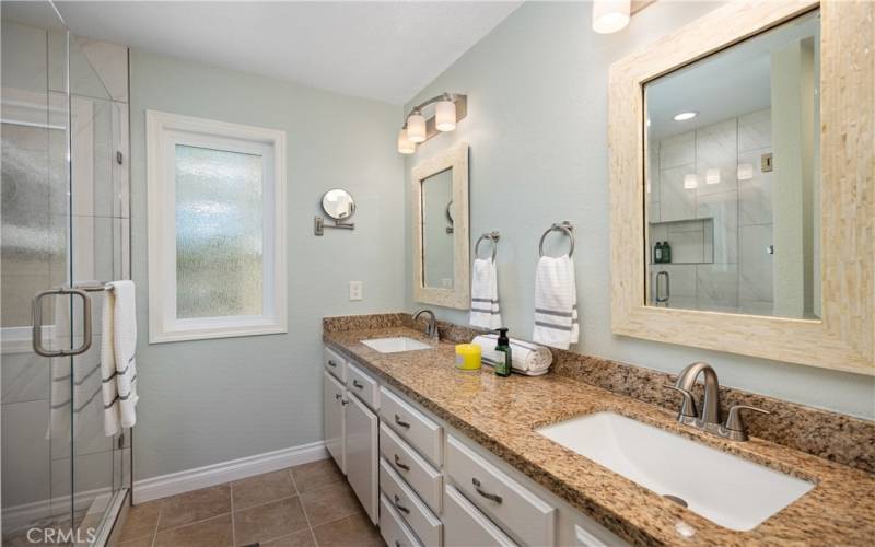 Recently Remodeled Primary Bath with Dual Vanity, Granite Counters, and Step-in Shower with Glass Enclosure