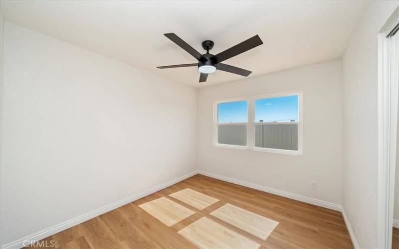 Bedroom 2 with remote ceiling fan on timer. New closet door and paneled entry door.