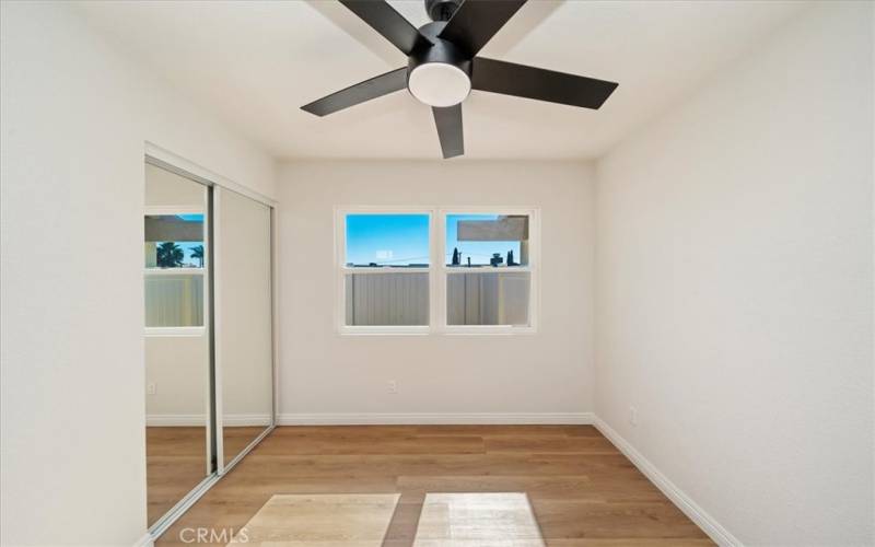 Bedroom 1 with remote ceiling fan on timer. New closet door and paneled entry door.