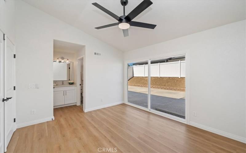 Primary bedroom 4. Featuring paneled French door entry and access to the patio.