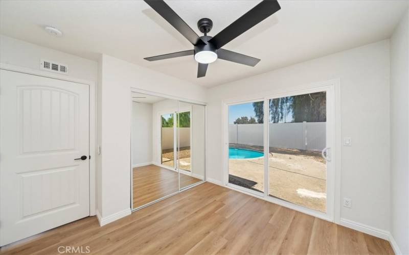 Bedroom 3 with remote ceiling fan on timer. New closet door and paneled entry door plus direct access to the private backyard.